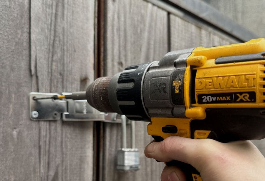Locksmith & Security technician installing gate hardware and padlock