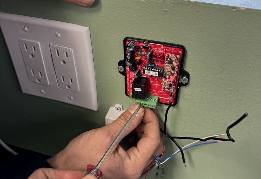 Locksmith & Security technician wiring an access control relay board